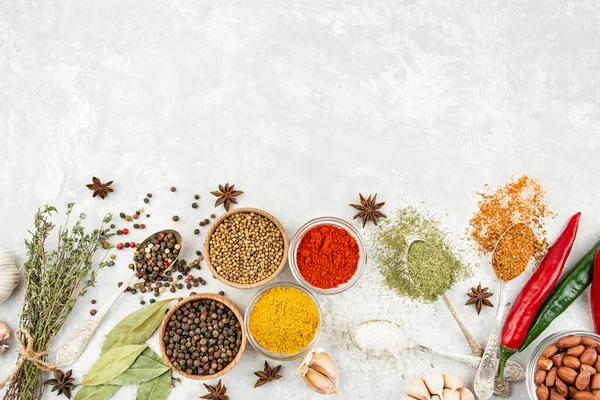 A variety of spices and herbs on a light table. Preparing the background. View from above. Ingredients for cooking. Table background menu.