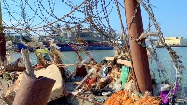 Muelle del puerto Área de aguas de la bahía de Taganrog. Escombros marinos en una cerca de alambre de púas. Contaminación ambiental. Medidas medioambientales. — Vídeos de Stock