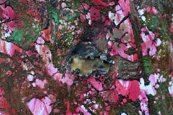 Yanmış selofan filmiyle pembe arka plan. Ateşin ve sıcaklığın etkisiyle polimerlerin erimesi.