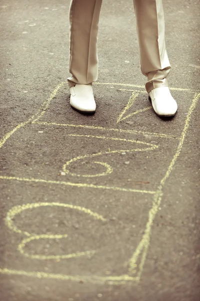 Piernas, botas blancas y números amarillos sobre un asfalto Fotos de stock libres de derechos