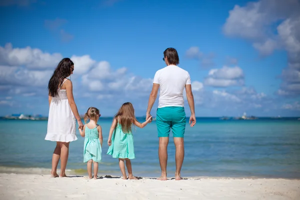 Joven hermosa familia con dos niños caminando en la playa — Foto de Stock