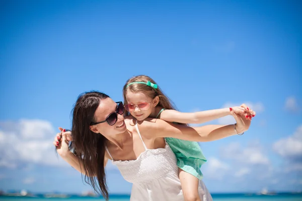 Mladá krásná matka a její rozkošná dceruška na tropické pláži — Stock fotografie