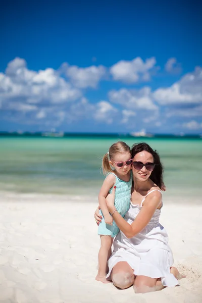 Junge schöne Mutter und ihre entzückende kleine Tochter am tropischen Strand — Stockfoto