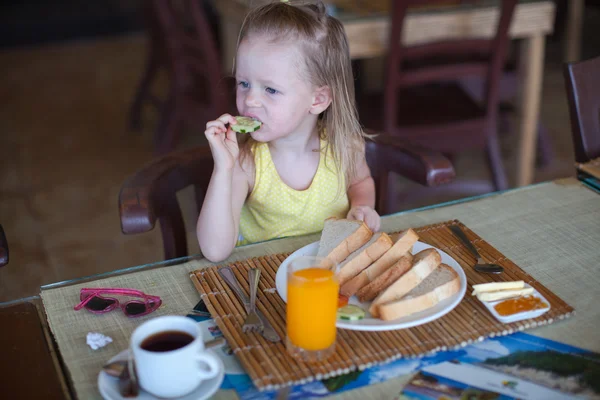 Entzückendes kleines Mädchen frühstückt im Resort-Restaurant — Stockfoto