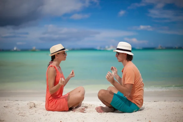 Νεαρό ζευγάρι απολαμβάνει μεταξύ τους και η γιόγκα σε μια παραλία — Φωτογραφία Αρχείου