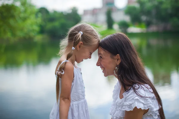 Young beautiful mother and her daughter having fun outdoors — Stock Photo, Image