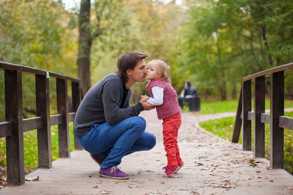 Отец целует свою маленькую дочь в парке — стоковое фото