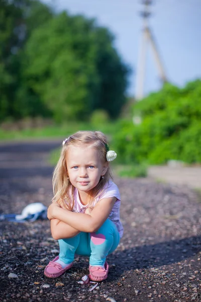 Milá dívka, sedící na jejich venkovní kýt a laughting — Stock fotografie