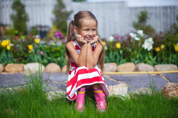 Hermosa chica sentada en su jardín y riendo —  Fotos de Stock