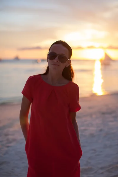Junge schöne Frau am tropischen Strand bei Sonnenuntergang — Stockfoto
