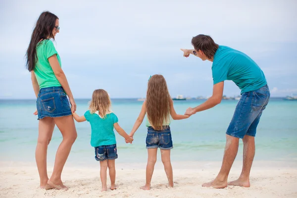 Vista trasera de la hermosa familia con dos niños en la playa exótica —  Fotos de Stock