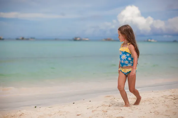 Adorable little girl in beautiful swimsuit walking at tropical beach — Stock Photo, Image