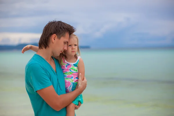 Portrait of a little girl hugging with dad on the beach — Stock Photo, Image