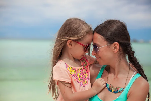 Porträt eines kleinen Mädchens, das sich mit seiner Mutter am Strand umarmt — Stockfoto