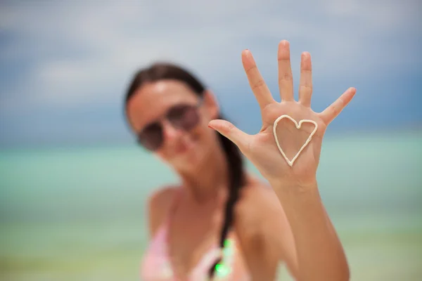 Primer plano de la mano de la niña con el corazón en la palma pintada por crema solar —  Fotos de Stock