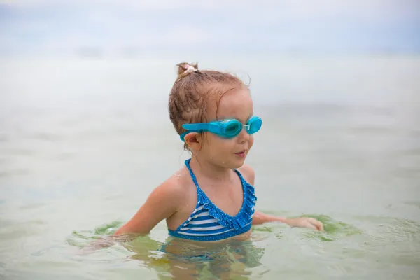 Bambina con gli occhiali per nuotare e tuffarsi nel mare — Foto Stock