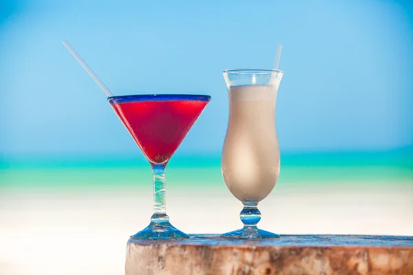 Weiße Pina Colada und rote Margarita auf dem Strandtisch — Stockfoto