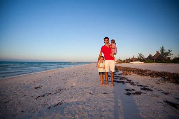 Genç Baba ve iki sevimli kızı egzotik bir plaj gün batımında — Stok fotoğraf