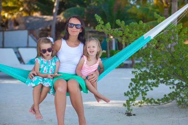 Fashion mother and her daughters relaxing in hammock in exotic resort — Stock Photo, Image