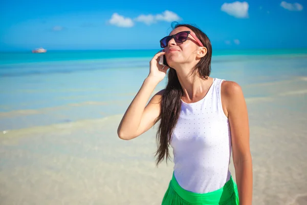 Młoda piękna kobieta mówi jej telefon na plaży — Zdjęcie stockowe