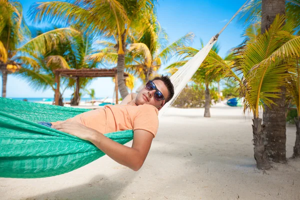 Jonge man in een hangmat op het exotische tropische resort — Stockfoto