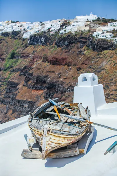 Famous old boat on the roof of house the background of Imerovigli — Stockfoto