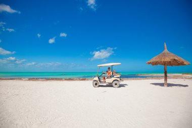 Baba ile iki kızı tropikal Beach'te golf arabası sürüş