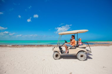Baba ile iki kızı golf arabası tropik ülke sürüş