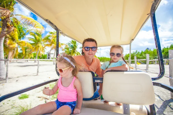 Jovem pai e suas filhas dentro do carrinho de golfe em um país tropical — Fotografia de Stock