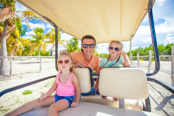 Back view of father and his little daughters inside golf cart at tropical country — Stock Photo, Image