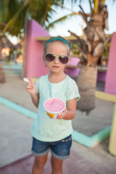Милая маленькая девочка ест мороженое на открытом воздухе — стоковое фото
