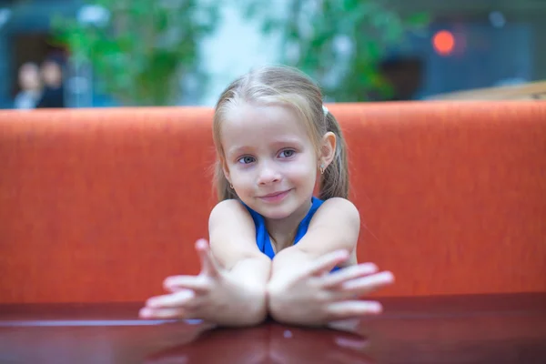 Closeup portret van schattig klein meisje zitten aan tafel. — Stockfoto