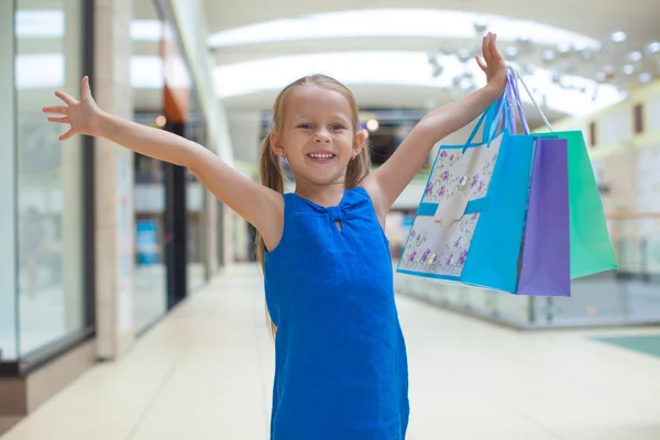 小小快乐的女孩与一个大型购物中心中的程序包 — 图库照片