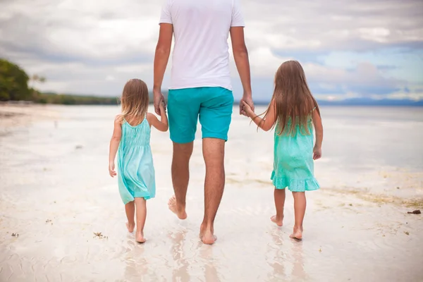 Vista trasera del padre y sus dos hijos caminando por el mar —  Fotos de Stock