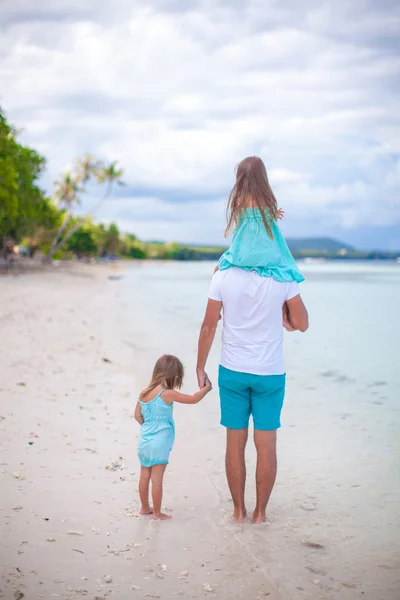 Pohled zezadu na otce a jeho dvě malé dcery, chůze u moře — Stock fotografie