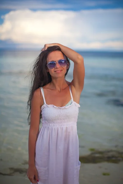 Hermosa joven de pie en el agua en la playa y mirando en la cámara —  Fotos de Stock