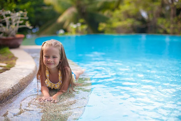 Χαριτωμένο κοριτσάκι στην πισίνα εξετάζει φωτογραφική μηχανή — Φωτογραφία Αρχείου