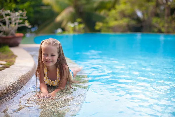 Menina bonito na piscina olha para a câmera — Fotografia de Stock