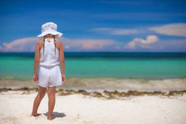 Adorable beautiful little girl alone looks at the sea on the white beach — Stock Photo, Image
