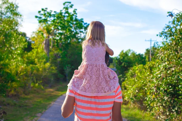 Meisje paardrijden op haar vader wandelen in de tuin — Stockfoto