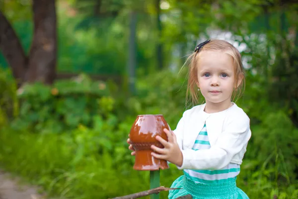 Portrat holčička stojí nedaleko historických dřevěných venkovských plot — Stock fotografie