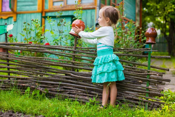 Adorable little girl standing near vintage wooden rural fence — Stock Photo, Image