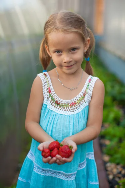 Sevimli küçük kız bahçede çilek ona ellerine ile portresi — Stok fotoğraf