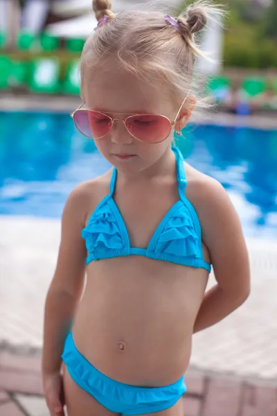 Nettes kleines Mädchen, das allein in der Nähe des Schwimmbades steht — Stockfoto