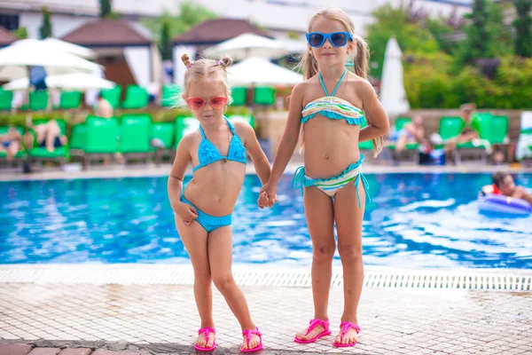 Zwei süße kleine Schwestern, die zusammen am Swimmingpool stehen — Stockfoto