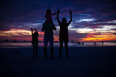 Aile Beach boracay üzerinde günbatımında dört silueti