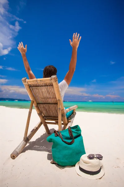 若い男が白い砂のビーチで木製の椅子でリラックス — ストック写真