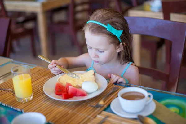 Sevimli küçük kız resort restoranda kahvaltı yapıyor — Stok fotoğraf