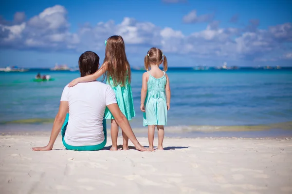 Back view of happy father with his two daughters on tropical beach vacation — Stock Photo, Image