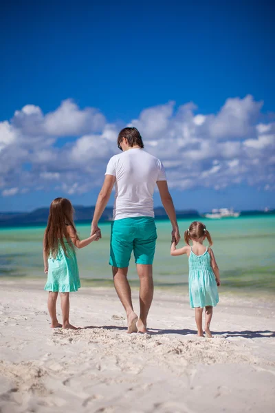 Vista posterior de padre y sus dos hijas caminando por el mar —  Fotos de Stock